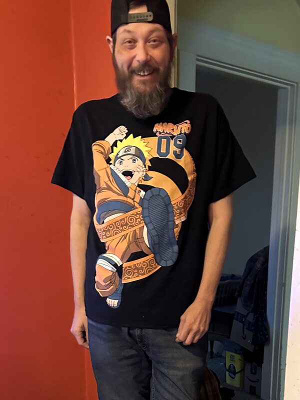 Brian Hupp in March 2026, standing at home in a black t-shirt and jeans, after losing about 300 pounds