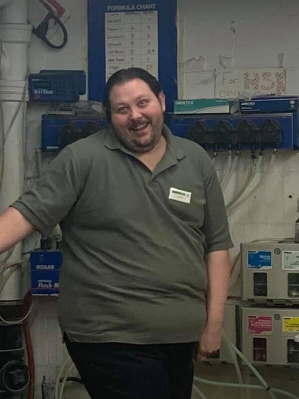 Brian Hupp standing at work in a green polo shirt, before he lost the weight